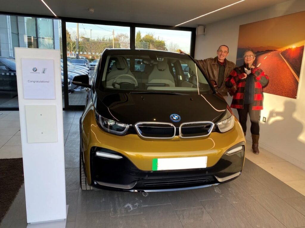 Julia Cotto and partner standing next to her BMW i3S.