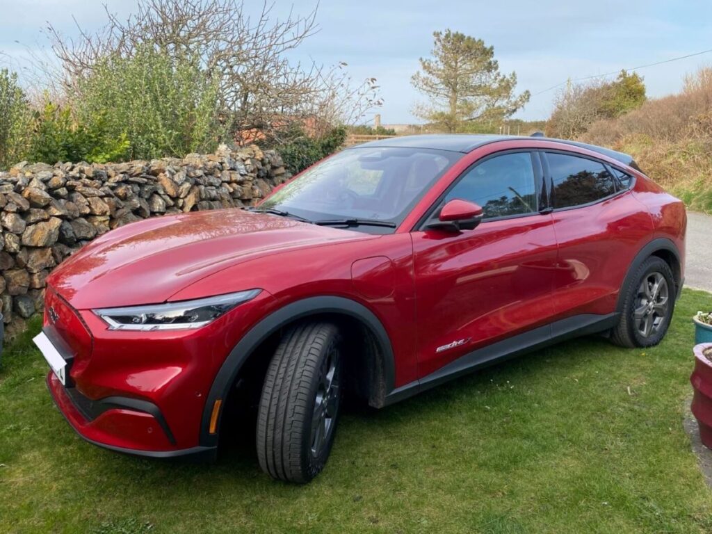 A Mustang Mach-E Long Range 2022 parked next to a dry stone wall