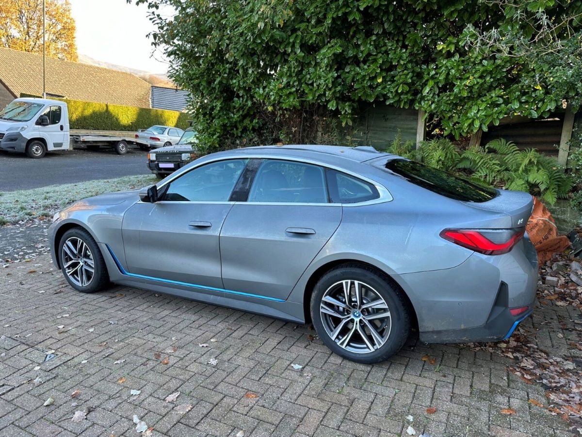 A side on view of a BMW i4 eDrive35 2023 parked on a brick driveway