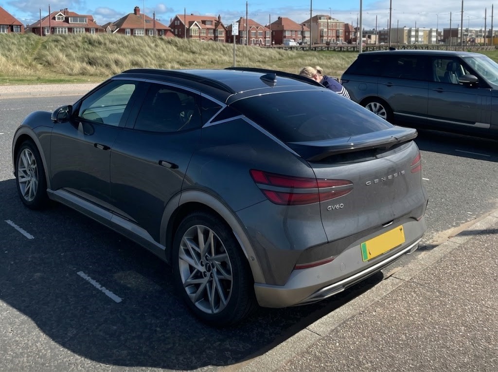 A Genesis GV60 Sport in a parking bay