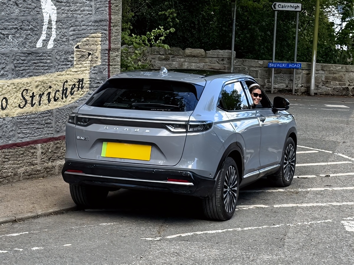 Rear three-quarter view of a 2025 Honda e:NY1 Advance in Urban Grey Pearl parked in Strichen, Aberdeenshire